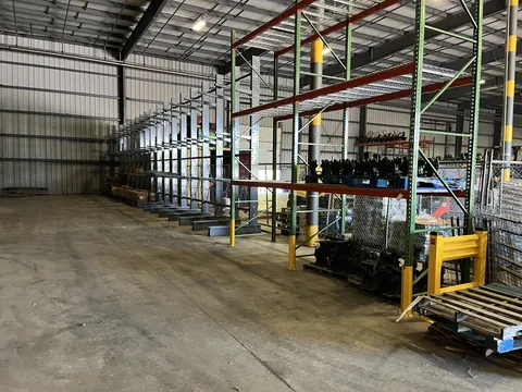Cantilever racking along a warehouse wall beside pallet racking