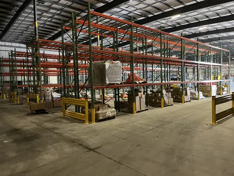 Pallet racking aisles with yellow rack guards on the uprights