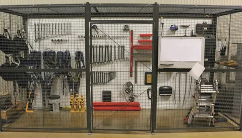 Tools stored inside a wire cage and partition